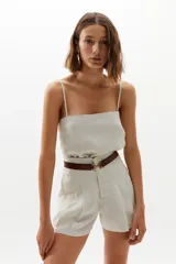 Short de lino 100% orgánico color natural, de cintura alta con tablas que le dan un calce holgado. Posee bolsillos laterales y cierre frontal con gancho metálico.