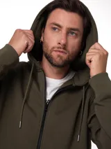 Buzo con cierre frontal completo y capucha, confeccionado en tejido fleece color verde oliva. Presenta bolsillos tipo canguro, puños y ruedo acanalados, y detalle de etiqueta con logo en el bajo.