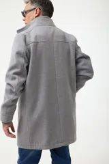 Gabán azul marino con cuello alto y pechera desmontable con cierre.