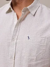 Camisa de manga corta con rayas verticales azules y blancas, confeccionada en algodón.