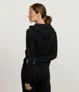 Campera deportiva de modal color gris melange, con cierre frontal por cremallera, capucha ajustable con cordones, mangas largas con puños ajustados y bolsillo tipo canguro.