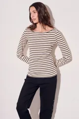 Remera de algodón color crema con rayas horizontales negras, cuello bote y mangas largas.