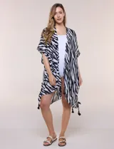 Kimono de gasa liviana con estampado animal print tipo cebra, en blanco y negro. Tiene mangas cortas amplias, diseño abierto al frente y ruedo asimétrico con detalles de borlas en las esquinas.