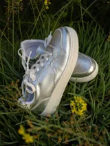 Championes urbanos Champion modelo Lina, color plateado con suela blanca y cordones blancos.