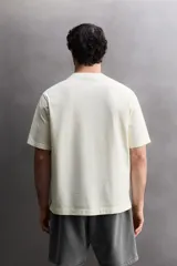 Camiseta de corte regular fit confeccionada en algodón, con cuello redondo y manga corta. Presenta un estampado frontal con el texto 'ATHLETICZ TRAINING CREW' con efecto desgastado.