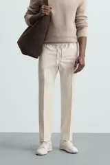 Pantalón regular fit color negro de tejido con viscosa, con cintura elástica ajustable con cordón, bolsillos frontales y traseros.