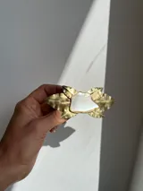 Broche hecho a mano en bronce con forma de flor y pieza central de nácar.