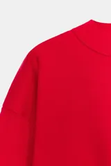 Sudadera de punto lisa en color rojo, con cuello subido y manga larga. Presenta un diseño de corte holgado con acabados en rib en puños y ruedo.