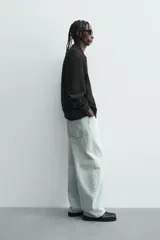 Cazadora bomber negra de corte regular fit, confeccionada en tejido efecto ante. Cuenta con cuello, puños y bajo en rib elástico, manga larga, bolsillos de vivo en la cadera y un bolsillo interior. Cierre frontal con cremallera.