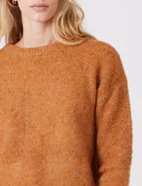 Buzo de lana melange color tostado, con cuello redondo y mangas largas.