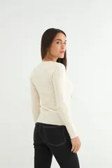 Sweater de punto fino en color negro, con cuello redondo y mangas largas, de corte ajustado al cuerpo.