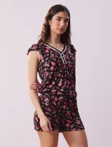 Conjunto de pijama de short y remera en tejido soft estampado. Remera de escote en V con aplique de puntilla, botones y detalle plisado. Short con cintura elastizada.