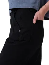 Pantalón de estilo carpintero en color negro, con corte relajado y pierna ancha. Presenta bolsillos laterales utilitarios, presilla para martillo y cierre frontal con botón y cremallera.