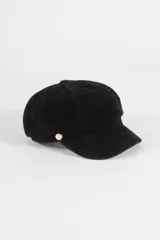 Boina tipo cap con visera, confeccionada en material con textura símil gamuza, con detalle de botón metálico lateral.