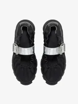 Zapato tipo bailarina color negro, con elástico en el borde superior y hebilla plateada.