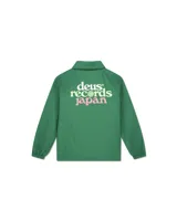 Chaqueta tipo coach verde con cuello camisero, cierre frontal de botones a presión y cordón ajustable en el ruedo. Presenta un logo circular blanco con texto en el pecho izquierdo.