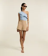 Short sastre de cintura alta color marrón, con bolsillos laterales y detalles de tachuelas metalizadas.