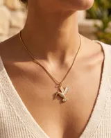 Collar de bronce dorado con cadena fina y dije colgante en forma de colibrí con detalles texturizados.