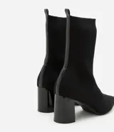 Botas de caña media de tejido de punto acanalado negro, con puntera fina y tacón geométrico.