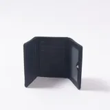 Billetera de cuero sintético color negro con diseño texturizado, solapa frontal con borde metálico plateado y cierre de broche.