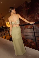 Pollera larga de gasa color bordó, con diseño de tiro alto, base fruncida y tajo lateral profundo decorado con volados verticales.