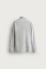 Camisa regular fit de manga larga con diseño de rayas verticales celestes y blancas, cuello italiano y cierre frontal con botones.