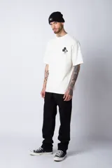 Remera negra de corte oversize confeccionada en algodón pesado, con estampa pequeña de Mickey Mouse en el pecho y diseño gráfico en la espalda.