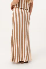 Pollera larga tejida a rayas verticales en color rojo y blanco, con pretina elástica y tajos laterales profundos que aportan movimiento.