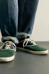 Zapatilla casual de hombre con diseño combinado en color naranja y marrón oscuro, con cordones y suela de goma en contraste.