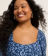 Vestido midi con estampado animal print de leopardo, escote cuadrado, mangas cortas anchas y abertura en el bajo.