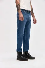 Jean de corte recto y tiro medio, en color azul clásico con acabado lavado. Presenta cierre de cremallera y botón metálico, con diseño de cinco bolsillos.