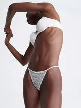 Colaless blanco con encaje elástico transparente y tiras delgadas.