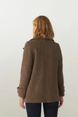 Chaquetón color beige con cuello, abrochadura simple con botón en el cuello, bolsillos ojal y detalle de martingala en mangas. Prenda con forro al tono.