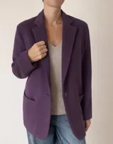 Blazer de corte oversize confeccionado en baby alpaca, color morado. Presenta solapas clásicas, cierre frontal con un botón al tono y dos bolsillos de parche delanteros.