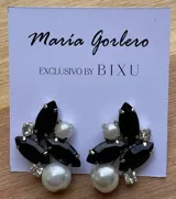 Par de caravanas con forma de racimo, con perlas blancas, piedras negras en forma de hoja y strass plateado. Cierre a presión.