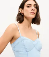 Vestido largo de jean celeste con escote corazón, breteles finos y recortes estructurados en el busto.