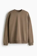Buzo deportivo color marrón, de diseño liso con cuello redondo y hombros caídos. Cuenta con detalles de rib acanalado en el cuello, los puños y el dobladillo inferior.