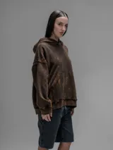 Hoodie oversize de algodón con efecto desgastado y oxidado. Presenta costuras expuestas, detalles de roturas en los bordes, capucha y bolsillo frontal tipo canguro.