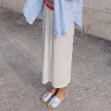 Sandalias planas estilo menorquina con capellada plateada y tira trasera de sujeción.