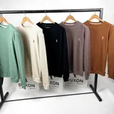 Buzo de tejido de punto color negro, con cuello redondo y logo bordado en el pecho.