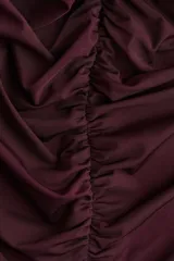 Top de punto elástico color bordó, con breteles anchos que se unen en la espalda. Diseño ceñido con frunces en la parte delantera que crean un leve efecto drapeado.