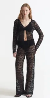 Saco calado negro con mangas largas y botones frontales.