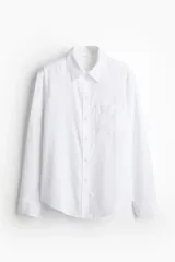 Camisa en tejido liviano de mezcla de lino y viscosa con cuello, botones adelante y canesú de doble capa con pliegue de caja en la espalda. Modelo de manga larga con bolsillo superior abierto, puños abotonados y bajo redondeado.