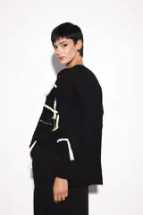 Sweater negro holgado con diferentes puntos y bordados a mano con hilo de lurex.