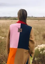 Tapado largo de paño con diseño color block en tonos marrón, verde, amarillo y naranja. Presenta solapas, bolsillos de parche en contraste rosa y un corte recto.