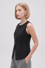 Chaleco negro sin mangas, con cuello redondo y cierre frontal de botones. Presenta un diseño entallado con bolsillos laterales simulados.