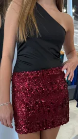 Minifalda de lentejuelas color bordó, con diseño ajustado y tiro bajo.