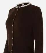 Cardigan de punto marrón de manga larga, con cierre frontal de botones y detalles de encaje blanco en el cuello redondo y los puños.