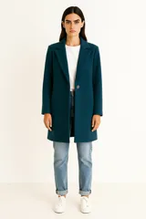 Tapado de paño color verde oscuro, con solapas clásicas, cierre frontal de un botón y mangas largas.