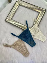 Pack de tres microtangas de encaje con diseño floral, cuentan con tiras laterales regulables y bordes con terminación en cinta elástica. El set incluye una prenda negra, una blanca con estampado floral negro y una beige con estampado floral negro.